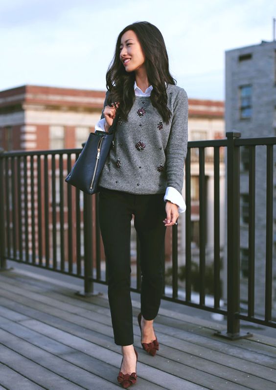 black jeans, a white shirt, a grey embellished sweater and burgundy bow shoes