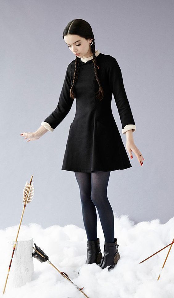 Wednesday Addams costume with a little black dress, a white shirt, blue tights and black booties
