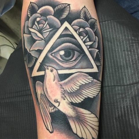 All seeing eye and white dove tattoo on the arm