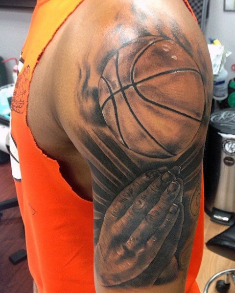 Ball and clasped hands in prayer tattoo