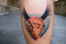 Ball with wings tattoo on the leg