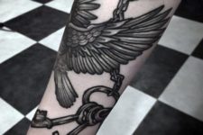 Bird and keys tattoo on the forearm