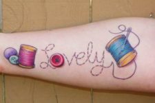 Colorful threads, needle and buttons tattoo