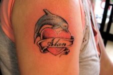 Dolphin and heart tattoo on the hand
