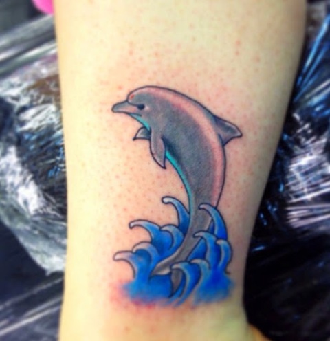 Dolphin and water tattoo on the leg