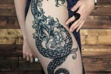 Dragon and flowers tattoo on the thigh