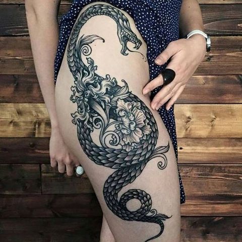 Dragon and flowers tattoo on the thigh