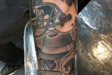 Football and helmet tattoo on the forearm
