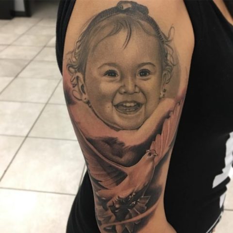 Half-sleeve dove and baby face tattoo
