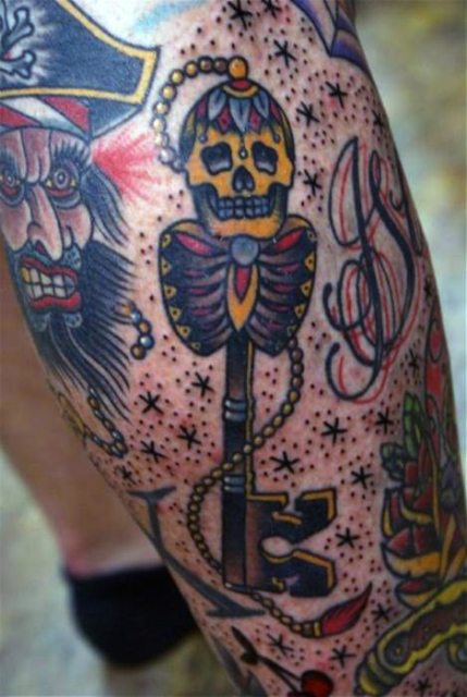 Key and skull tattoo on the leg