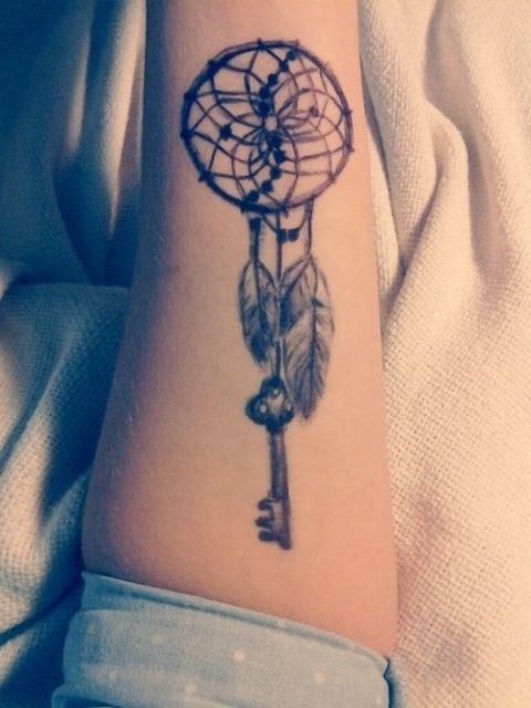 Single needle key tattoo on the upper arm.