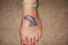 Light blue dolphin tattoo on the foot
