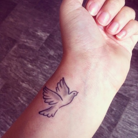 Minimalistic dove tattoo on the wrist