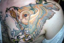 Owl and golden key tattoo on the chest