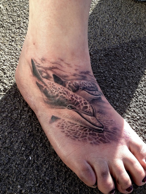 Realistic two dolphins tattoo on the foot