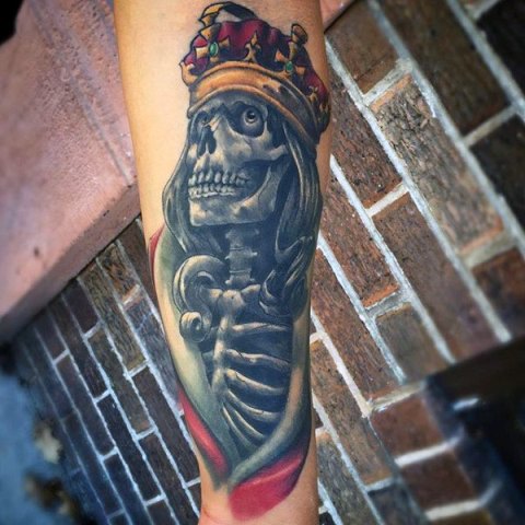 Skeleton and crown tattoo on the forearm