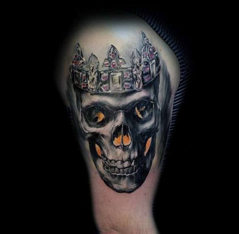 Skull and crown tattoo on the biceps