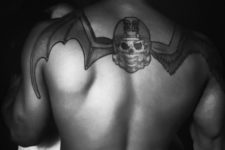 Skull and helmet with wings tattoo on the back