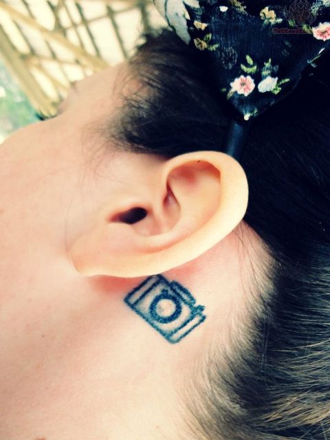 Tiny camera tattoo behind the ear
