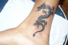 Total black dragon tattoo on the ankle