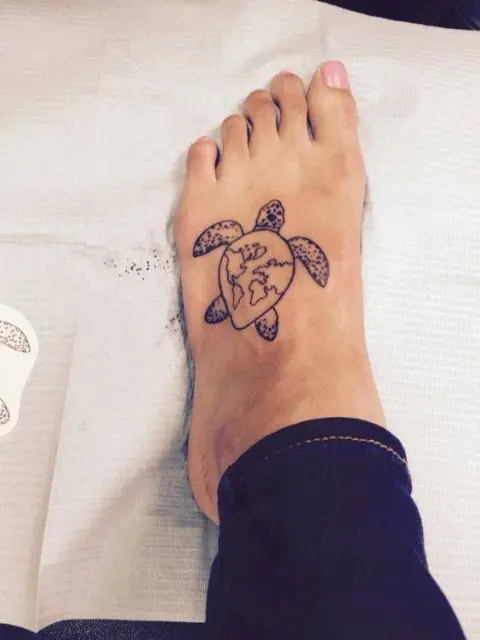 Turtle tattoo with world map image on the foot