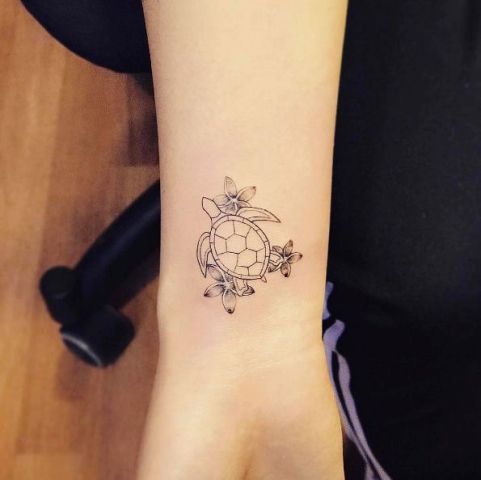 Turtle with flowers tattoo on the arm