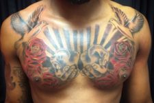 Two doves, red roses and hands tattoo on the chest