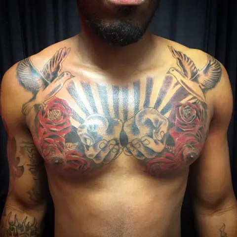 Two doves, red roses and hands tattoo on the chest