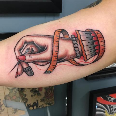 Unique sewing tattoo idea on the arm