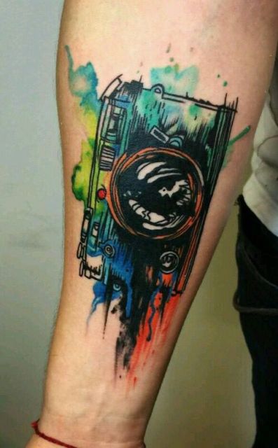 Watercolor camera tattoo on the forearm
