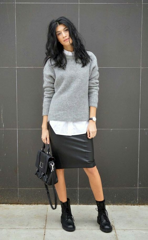 a white shirt, a grey sweater, a black leather knee skirt and boots for a creative and relaxed work look