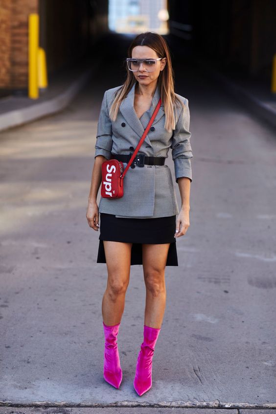 a fashionable look with a jacket, a black symmetrical skirt and hot pink sock boots