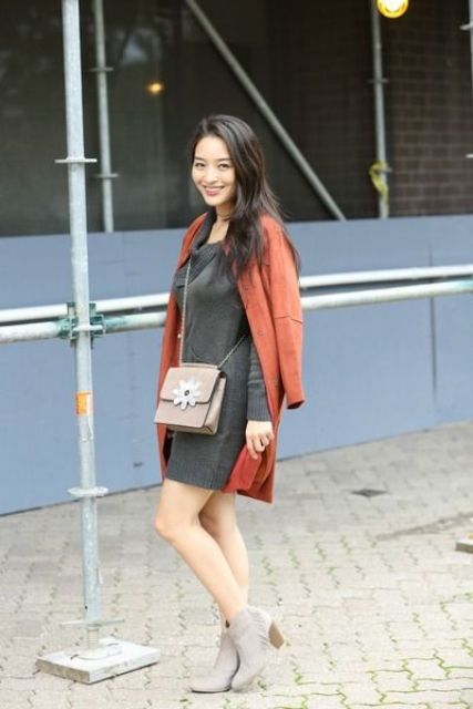 a grey sweater dress, a burnt orange coat, grey suede booties and a matching bag