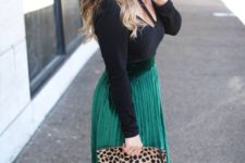 a cutout black top, an emerald pleated midi skirt, black shoes and a leopard clutch