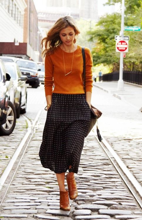 a burnt orange long sleeve top, a printed midi skirt, cognac booties for a chic look