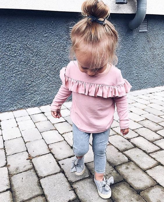 a pink shirt with ruffles, grey leggings and grey flats with bows