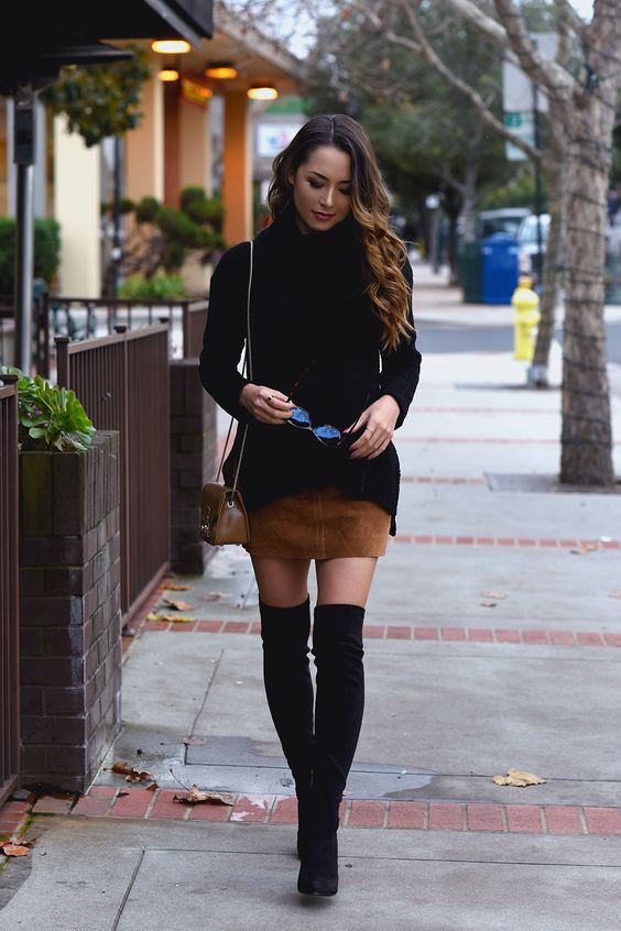 a black sweater, an ocher suede mini skirt, black suede tall boots and a small bag