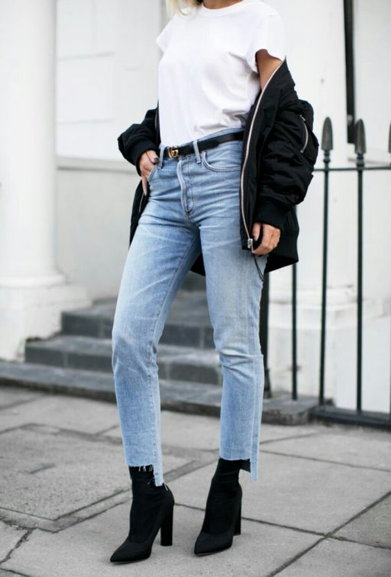 a white tee, a black bomber jacket, blue jeans with a rough edge and blakc suede sock boots
