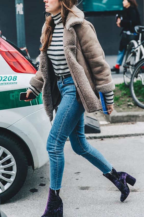 a winter look with blue jeans, a striped turtleneck, a shearling coat and purple velvet sock boots