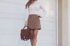 16 a white turtleneck, a brown mini skirt with a row of buttons, brown booties and a backpack