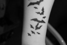 Several bats tattoo on the forearm