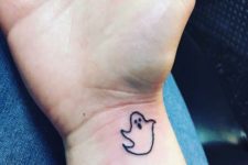 Tiny black-contour tattoo on the wrist