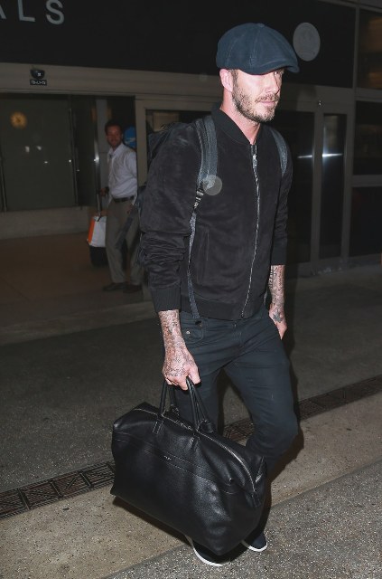 With black bomber jacket, backpack, black pants and leather bag