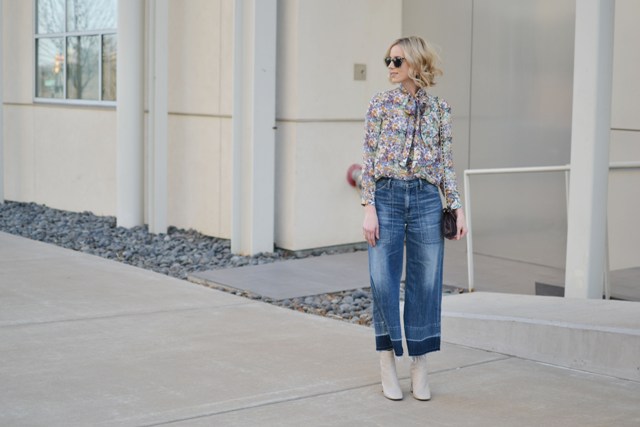 With floral blouse, white boots and clutch