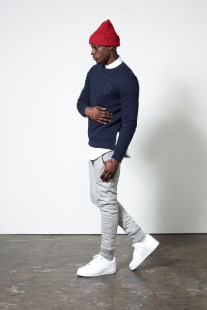With navy blue sweater, gray pants and white sneakers