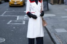 With navy blue trousers, black turtleneck, white coat and beige bag