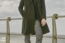 With olive green coat, gray pants and boots