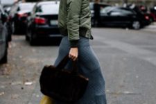 With olive green jacket, midi skirt and black bag
