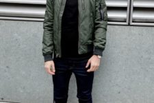 With olive green puffer jacket, black pants, white and red sneakers and cap