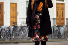 With orange shirt, floral skirt, flat boots and gloves